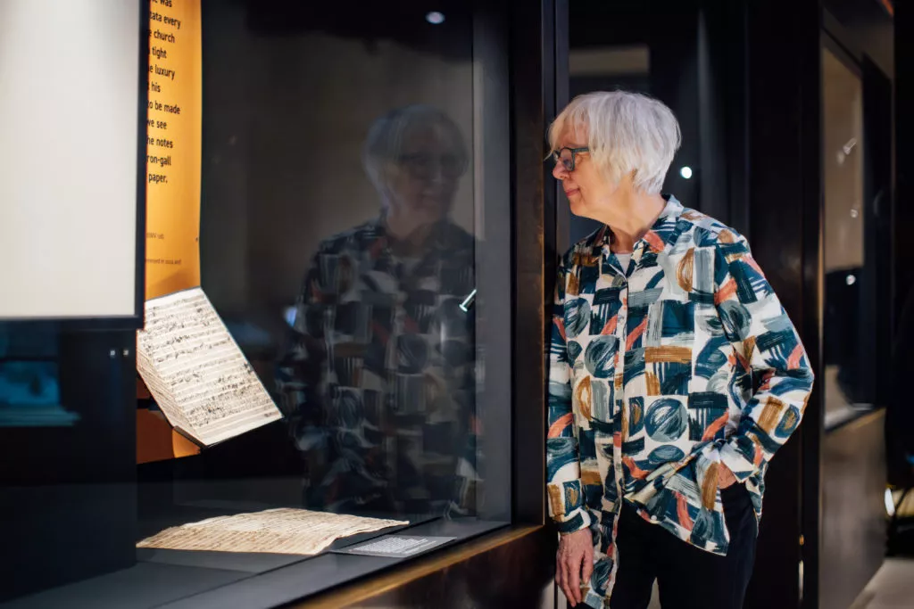 Composer Judith Weir looking at the manuscript in the Weston Library;.